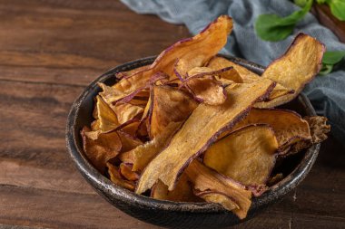 Tatlı patates cipsi kasede, masada.
