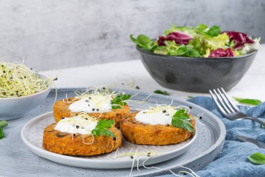 Izgara vejetaryen burger, bezelye, sebze ve seramik tabakta maydanoz yaprakları..