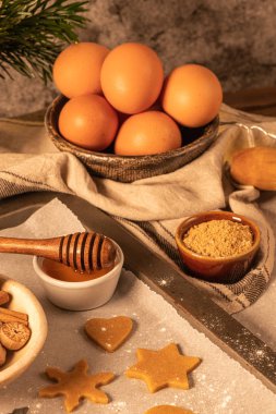 Zencefilli kurabiye yapıyorum. Çiğ hamur, zencefilli çörek adam, noel ağacı, yıldız, kırsal masada kağıt üzerinde kar taneleri merdaneli iğne. Pişirme için hazırlanılıyor