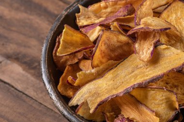 Tatlı patates cipsi kasede, masada.