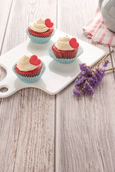 Red velvet heart cupcakes with cream cheese frosting and a red heart for Valentine's Day. Top view with copy space — Stock Photo, Image