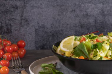 Salata. Bahar sebze salatası. Domatesli, elmalı, fındıklı, tohumlu ve limonlu taze sebze salatası. Salata kasesine zeytin yağı dökülüyor.