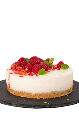 Beyaz zemin üzerinde ahududu, erik ve nane yapraklı cheesecake.