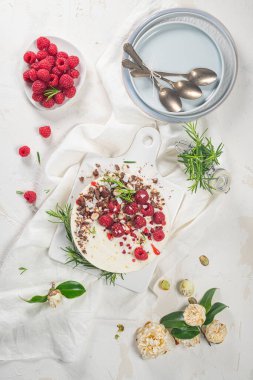 Mutfakta ahududu, çikolata, fındık ve biberiye yapraklı cheesecake.