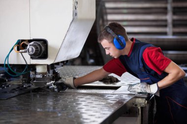 Bir fabrika içinde eylem Metal Sanayi işçisi basın makine çelik parça çalışılacak hazır tutuyor.