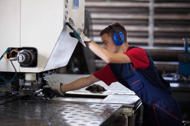 Bir fabrika içinde eylem Metal Sanayi işçisi basın makine çelik parça çalışılacak hazır tutuyor.