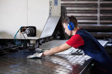Bir fabrika içinde eylem Metal Sanayi işçisi basın makine çelik parça çalışılacak hazır tutuyor.