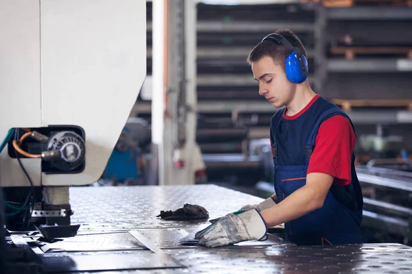 Bir fabrika içinde eylem Metal Sanayi işçisi basın makine çelik parça çalışılacak hazır tutuyor.