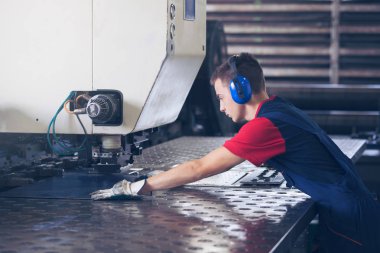 Bir fabrika içinde eylem Metal Sanayi işçisi basın makine çelik parça çalışılacak hazır tutuyor.
