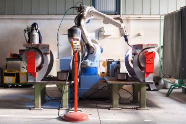  Mekanik kol gerçekleştirir kaynak metal bileşenleri bir işçi tarafından destekli hazır.