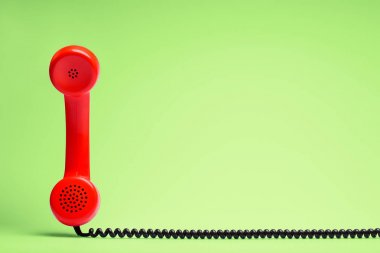 Retro tarzı yeşil zemin üzerine kırmızı telefon.
