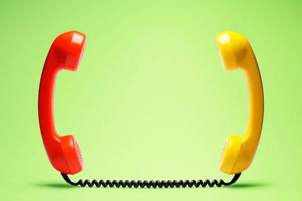 Czerwony Żółty Telefon Zielonym Tle — Zdjęcie stockowe