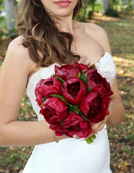 Γαμήλια ανθοδέσμη των κόκκινων τριαντάφυλλων στα χέρια της νύφης — Φωτογραφία Αρχείου