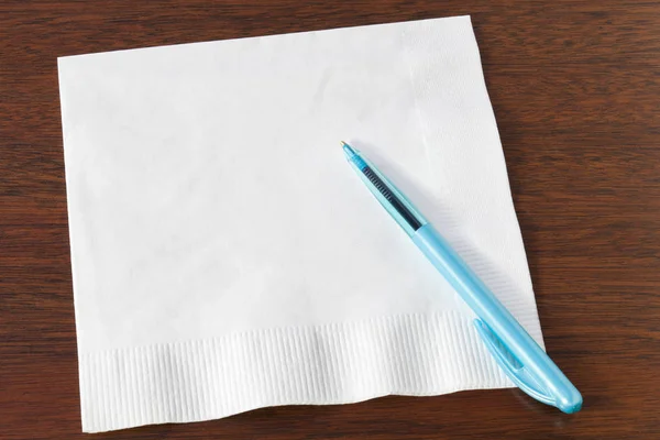 Napkin and Turquoise Biro on Dark Oak — Stock Photo, Image