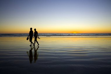 Young Couple Walking on Romantic Beach at Sunset clipart