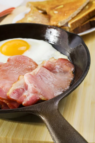 铸铁煎锅中的鸡蛋和熏肉 — 图库照片