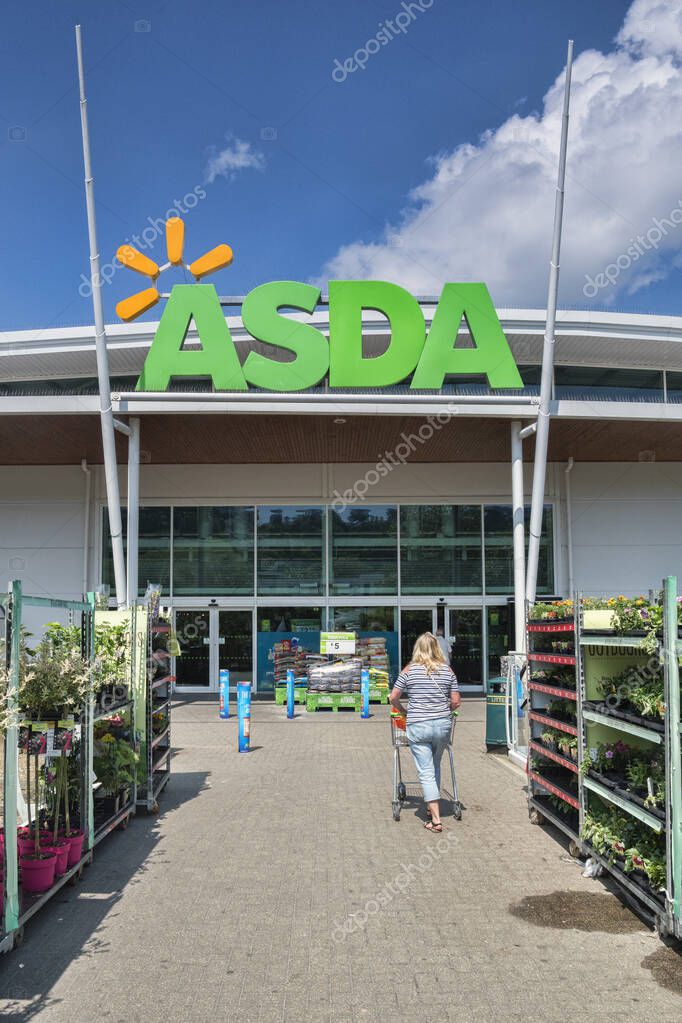28 May 2018: Newton Abbot, Devon, UK - Asda supermarket entrance, with a woman pushing a trolley towards it.