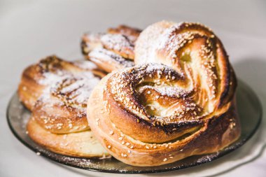 bir plaka üzerinde kırmızı buns ile pudra şekeri serpilir