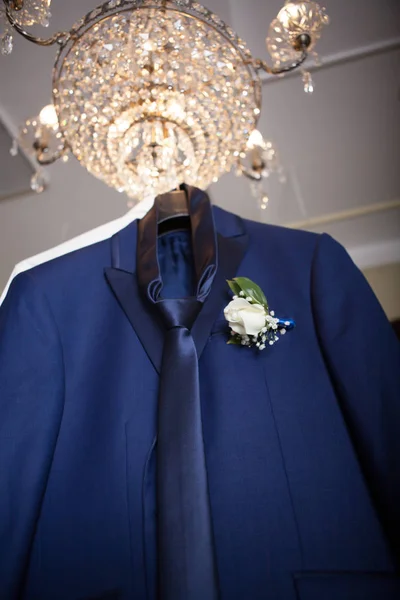 groom's suit hanging on a chandelier