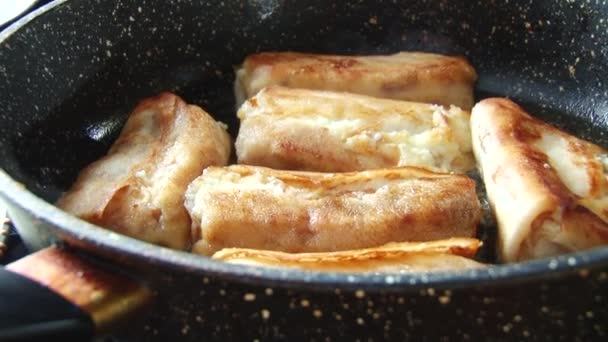 Traditioneel Russisch gebakken gevulde pannenkoeken met cottage kaas op een koekepan. — Stockvideo