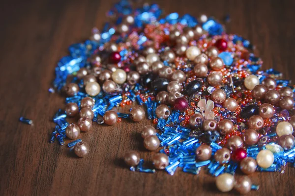 Colorful beads on the wooden table. Close-up
