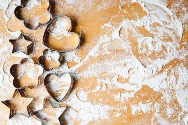 Unlu ahşap bir masada metal şekilli kurabiye keskisi. Metin için boşluk olan tepeden görünüm