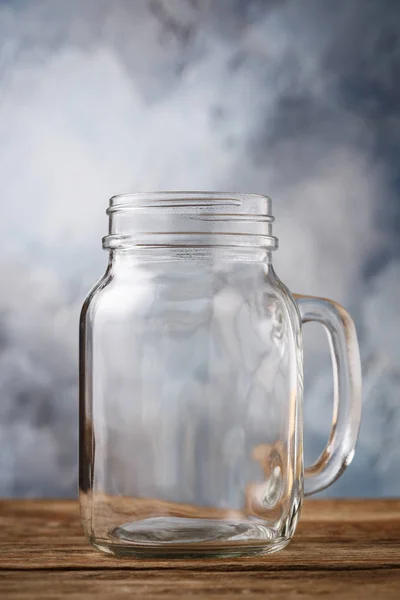 Empty glass jar on a wooden table, close-up