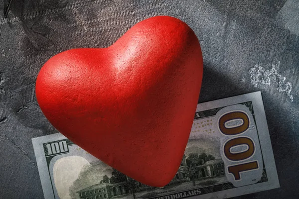 Heart on a hundred dollar bill, close-up. Concept for the treatm