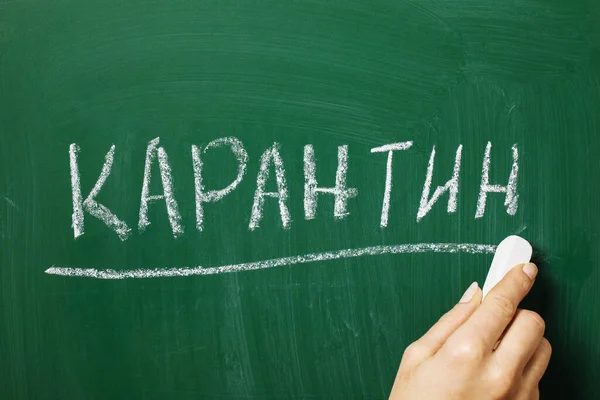 The inscription in Russian letters: Quarantine. On the blackboard, the teacher wrote the word quarantine. Seasonal Viral Disease Concept