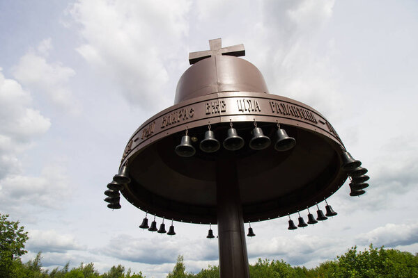 Metal bells and cross symbol silhouette in Ukraine of Europe. Mgar orthodox male monastery and memorial to famine (holodomor) in country. Famous place near Lubny, Poltava region