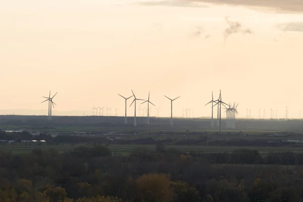 A wind farm or wind park, also called a wind power station or wind power plant at the sunset time