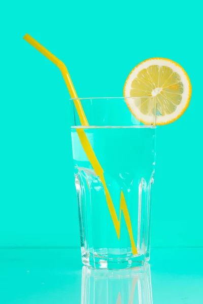 Getränk, Wasser mit Zitrone im Glas, auf blauem Hintergrund. — Stockfoto