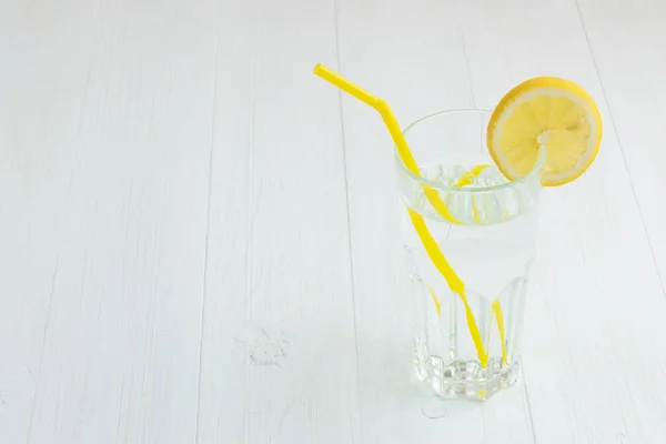 Trinken, Wasser mit Zitrone im Glas, auf weißem Hintergrund. — Stockfoto