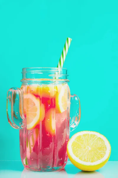 Rotes Getränk mit Zitrone in einem Glas Kaktus, auf blauem Hintergrund. — Stockfoto