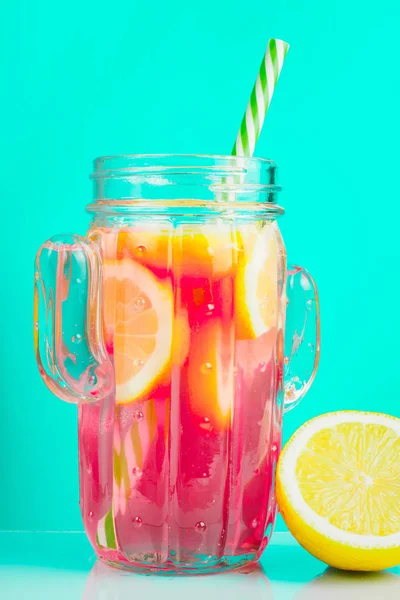 Rotes Getränk mit Zitrone in einem Glas Kaktus, auf blauem Hintergrund. — Stockfoto