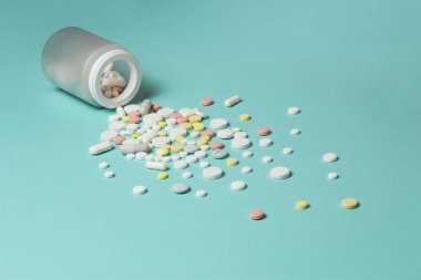 Mavi bir arka plan üzerine bir şişe hap.