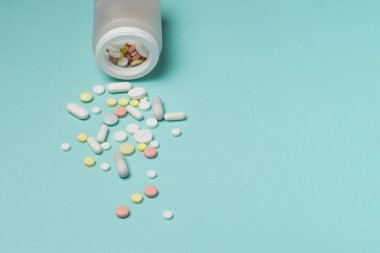 Mavi bir arka plan üzerine bir şişe hap.