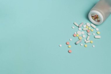 Mavi bir arka plan üzerine bir şişe hap.