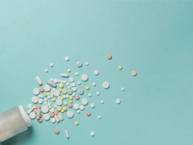 Mavi bir arka plan üzerine bir şişe hap.