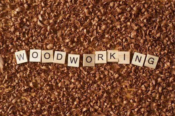 Woodworking word writen with letters on a wood chips — Stock Photo, Image