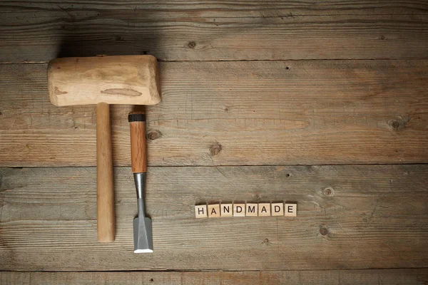 Handgemachtes Wort mit Schlägel und Meißel auf Holzwerkbank — Stockfoto