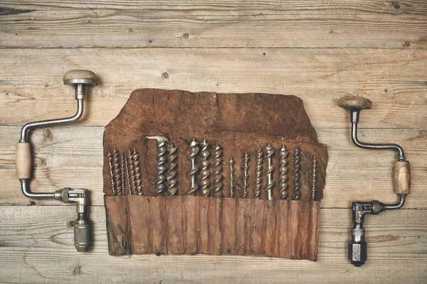 Brocas com brocas em rolo de ferramentas de couro na bancada de madeira — Fotografia de Stock
