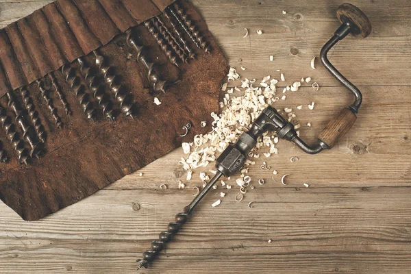 Bohrspange mit Bits in Leder-Werkzeugrolle auf einer Holzwerkbank — Stockfoto