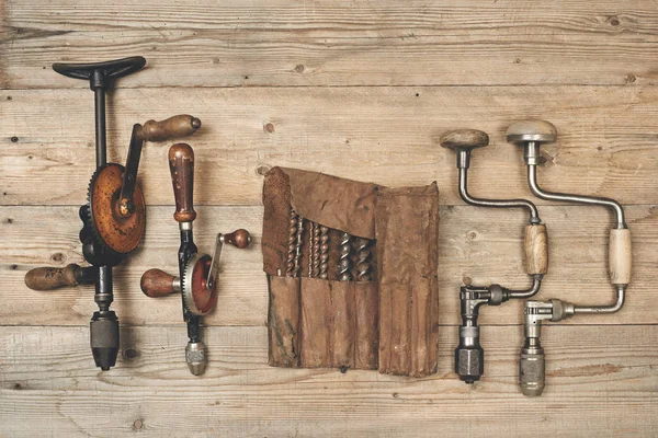 Boor bretels met stukjes in leder gereedschap rollen op een houten workbenc Stockfoto