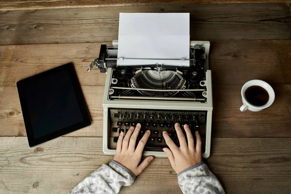 La mujer está escribiendo en una vieja máquina de escribir . — Foto de Stock