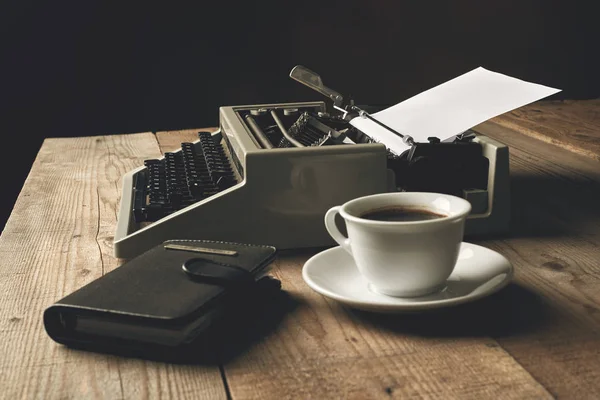 Old typewriter on wooden table with blank paper Stock Picture