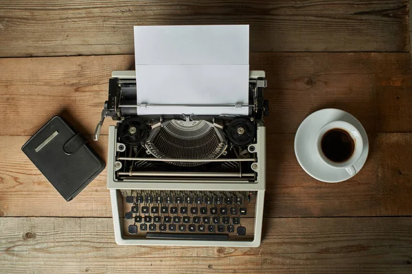 Old typewriter on wooden table with blank paper Royalty Free Stock Images