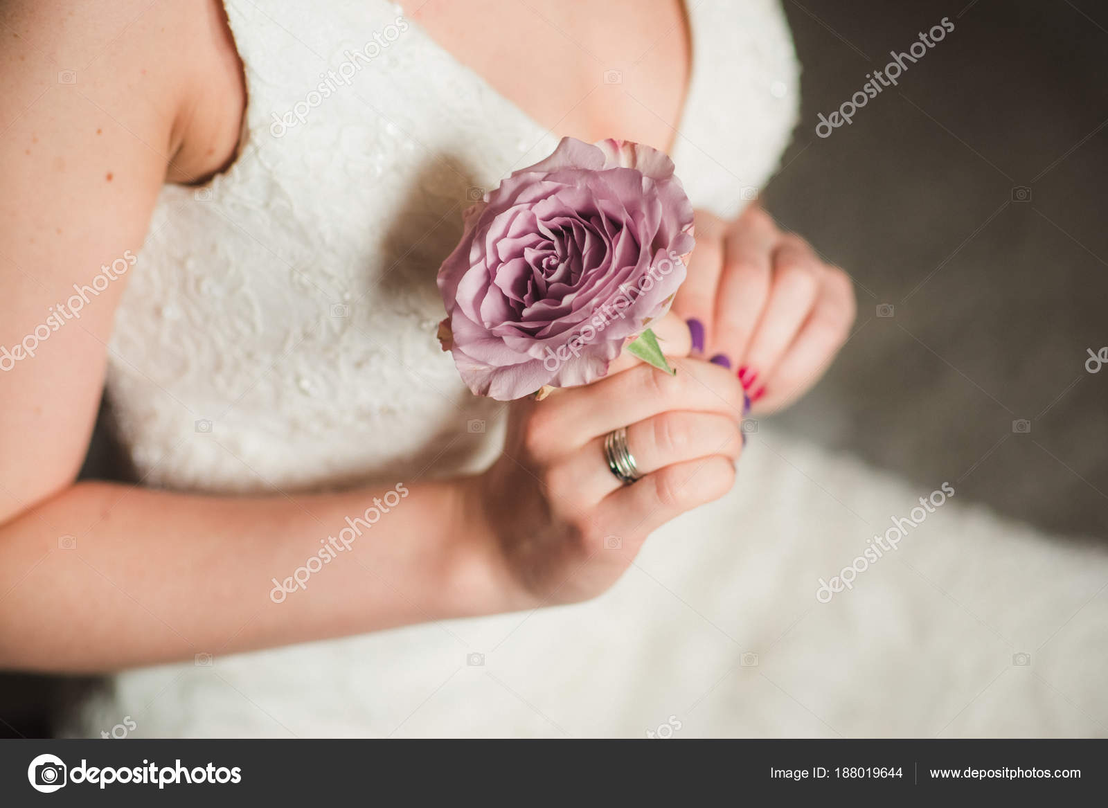 Close Female White Wedding Dress Holding Beautiful Purple Flower