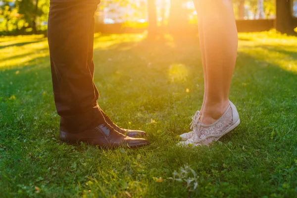 緑の草の背景に靴の男性と女性の足のクローズ アップ — ストック写真
