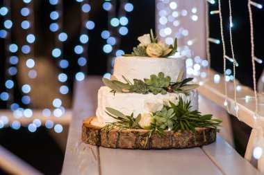 yakın çekim çiçek ve kutlama için yeşil yaprakları ile lezzetli düğün pastası